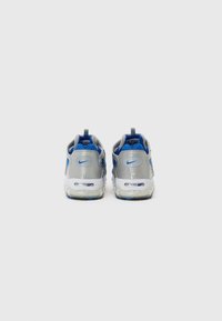 Baskets Nike avec une tige grise, des accents bleus, des détails en mesh et une semelle transparente présentant un amorti à air visible.