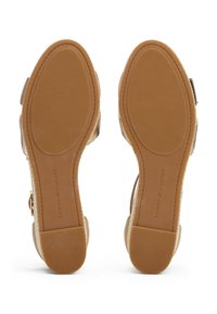 Camelkleurige leren platformsandalen met een gestructureerde rubberen zool, een gespsluiting en een vlakke hak. Logo op de zool gestempeld.