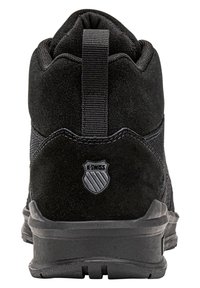 Zwarte K-Swiss sneaker gezien vanaf de hak, met suede materiaal, een trekhaak en een gestructureerde rubberen zool.