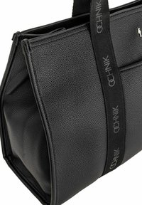 Czarna skórzana torebka o fakturze z podwójnymi czarnymi uchwytami, z powtórzonym napisem "OCHNIK" oraz małym srebrnym logiem w kształcie zwierzęcia w prawym górnym rogu.