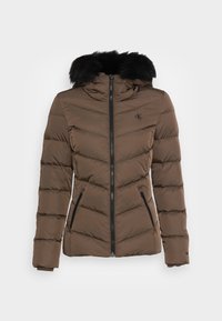 Brun puffjacka med avtagbar svart pälsluva. Har dragkedja fram, sidofickor och chevronstickningsdesign.