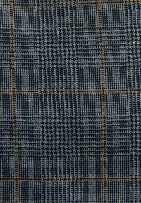 Tissu bleu texturé présentant un motif à carreaux avec différentes nuances. Les accents notables comprennent des lignes orange et bleu clair créant de la profondeur.