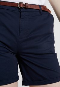 Mörkblå shorts i en bomullsblandning, med rak skärning, en framficka och ett brunt strukturerat bälte med en rund spänne.