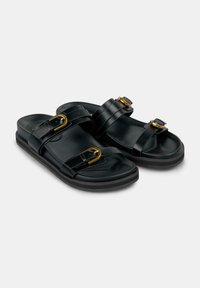 Sandali neri con due cinturini larghi, dotati di fibbie in tono oro. Texture liscia con una soletta sagomata e suola in gomma nera.