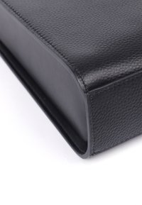 Sort læderpose med en struktureret overflade, afrundede kanter og syt detaljer, der har et elegant, minimalistisk design.