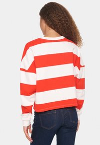Felpa a maniche lunghe a righe rosse e bianche con un design cropped e scollo a coste. Tessuto morbido e vestibilità rilassata.