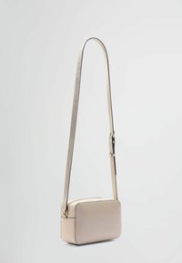 Metallic guld crossbody taske med rektangulær form, glat tekstur og justerbar rem. Den har et diskret design med minimale hardware detaljer.