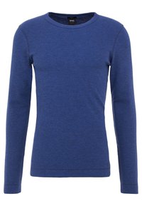 Långärmad topp med rund halsringning, tillverkad av strukturerad blått tyg. Har en enkel design och en logotagg vid halsringningen.