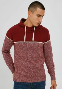 Sweat à capuche bordeaux et blanc avec texture mélang�ée. Comprend une section supérieure contrastante et des cordons de serrage avec des accents en bois.