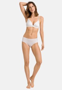 Witte lingerie set met een driehoeksbeha met dunne bandjes en bijpassende hooggewaisted slip, gladde textuur en eenvoudige snit.