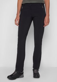 Black hiking pants made of lightweight fabric, featuring a slim fit, zippered pockets, and articulated knees for mobility. Paired with black footwear.