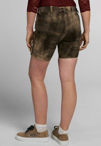 Braune Wildledershorts mit einer strukturierten Oberfläche, ausgestattet mit einem Rückenschnürdetail und einem Kontraststich entlang des Saums. Tragen mit hellen Socken und Sneakers.