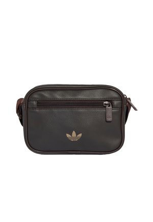 Petit sac bandoulière en cuir noir avec poche zippée à l'avant et logo trèfle beige Adidas au centre devant.
