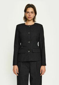 Čierny pruhovaný blazer s okrúhlym výstrihom, piatimi gombíkmi a dvoma prednými vreckami. Textúrovaná tkanina s prispôsobeným strihom.