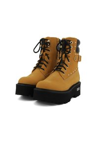 Stivali platform in pelle color cuoio con lacci neri, occhielli in metallo, zip laterale e dettagli in borchie su suole spesse nere.