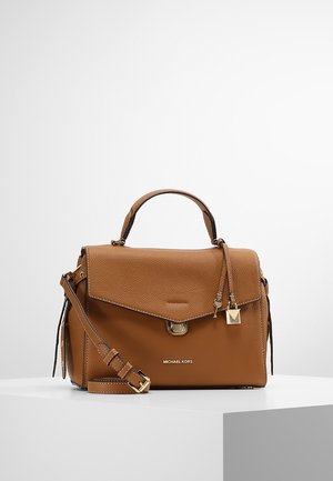 Tan leather handbag with a structured design, fold-over flap, gold-tone hardware, detachable strap, and embossed brand logo on the front.