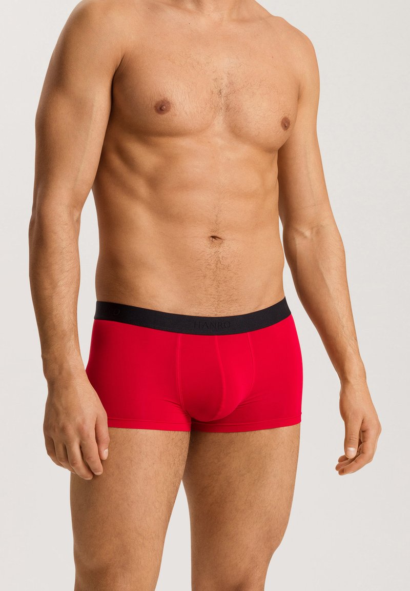 Boxer in rosso realizzati in un materiale liscio ed elastico, con una vita nera che presenta in modo discreto il nome del marchio "HANRO".