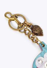 Portachiavi in metallo color oro con chiusura circolare, accento a forma di uccello testurizzato e charm in acrilico dai colori pastello con dettaglio di strass.