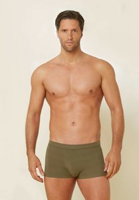 Olivgrön herrboxer, tillverkade av mjukt material, med en åtsittande design och elastisk midja, utan synliga mönster eller hängande delar.