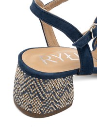 Sandalo in suede blu navy con tacco a piattaforma a motivo intrecciato, dotato di soletta in pelle color nocciola e cinturino regolabile con fibbia metallica.