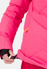 Giacca isolante rosa brillante con motivo a rombi, dotata di orlo regolabile con coulisse e zip arancione.