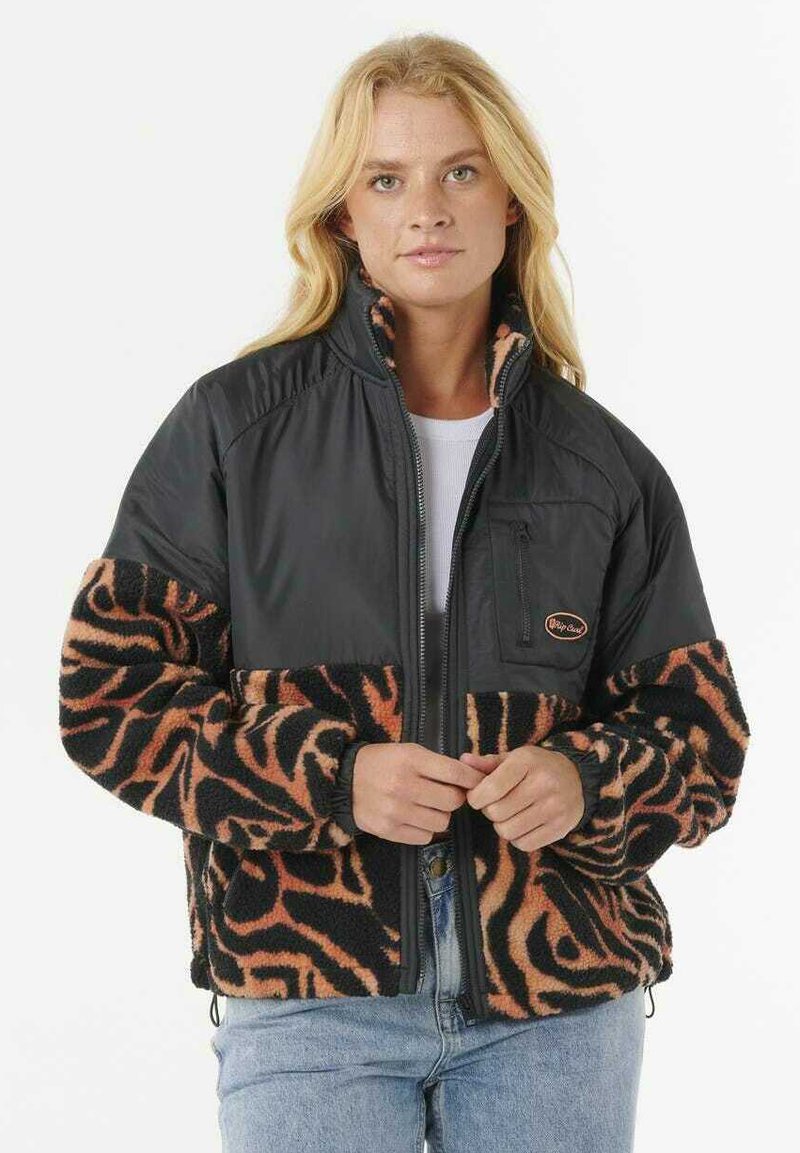 Chaqueta de forro polar con sección superior de nylon negro y sección inferior con estampado animal en naranja. Presenta un cierre con cremallera en la parte delantera y un pequeño bolsillo en el pecho.