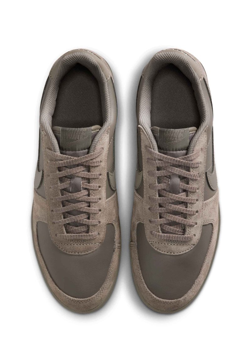 Grå sneakers med en blanding af glat læder og ruskind, rund tå, flade snørebånd og mesh-tunge. Accentueret med et logo på tungen.