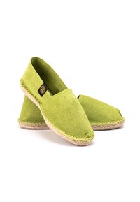 Espadrilles en toile verte avec un bout arrondi, semelles en jute et une étiquette logo noire sur le côté. Texture douce et construction légère.