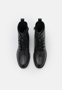 Černé kožené kotníkové boty s hladkým, lesklým povrchem, šněrováním na přední straně a bočním zipem pro snadné obouvání.
