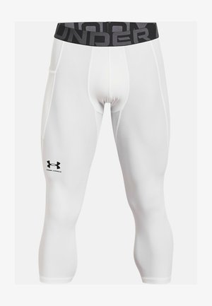 Leggings de sport blancs au design ajusté, avec une taille élastique portant le texte "UNDER" et un logo Under Armour noir sur la cuisse gauche.