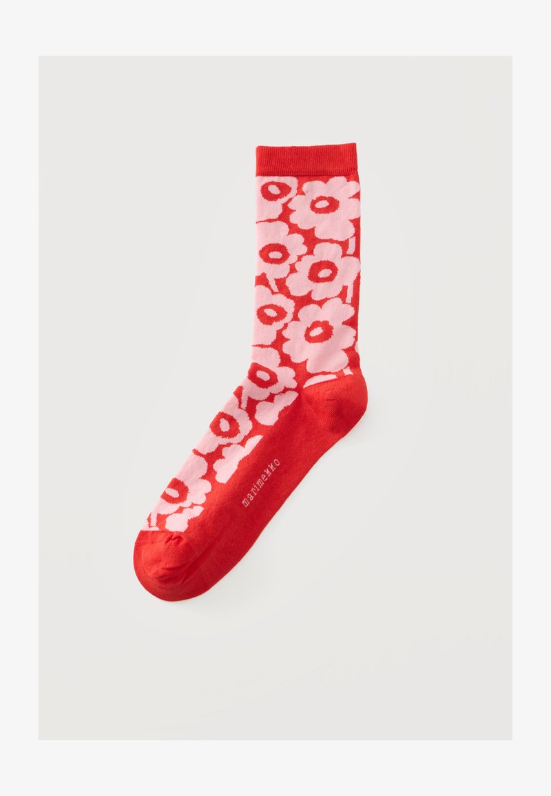 Червен чорап с ярък розов цветен мотив и думата "marimekko", отпечатана близо до пръстите, на светлосив фон.