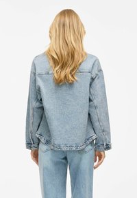 Hellblaues Denim-Jackett mit lockerer Passform, herabgesetzten Schultern und geradem Saum. Verfügt über rohe Kanten und Steppnähte.