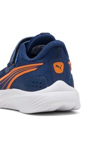 Marineblaue Sportschuhe mit orangefarbenen Akzenten, einer strukturierten Oberseite, Klettverschluss und einer weißen Laufsohle mit Wellenmustern.