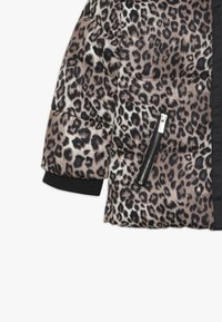 Pohodlná bunda s leopardím potiskem, s černými žebrovanými manžetami a kapsou na zip. Texturovaný povrch s prošívanými detaily.