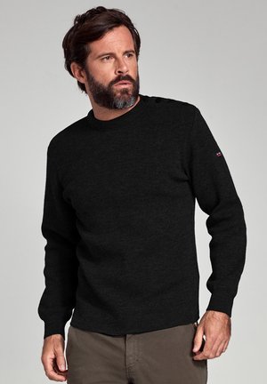 Schwarzer Strickpullover mit langen Ärmeln, rundem Hals und Knopfdetails an der Schulter. Glatte Textur und figurnahes Design.