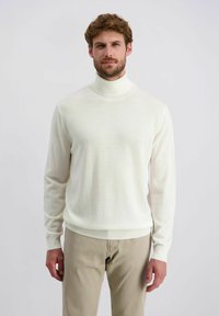 Cremfarbener Rollkragenpullover mit langen Ärmeln, aus weichem Stoff gefertigt. Hat ein tailliertes Design sowie gerippte Bündchen und Saum. Wird mit hellbeigen Hosen getragen.