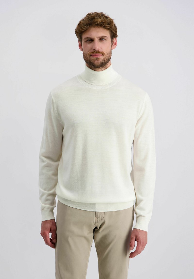 Cremfarbener Rollkragenpullover mit langen Ärmeln, aus weichem Stoff gefertigt. Hat ein tailliertes Design sowie gerippte Bündchen und Saum. Wird mit hellbeigen Hosen getragen.