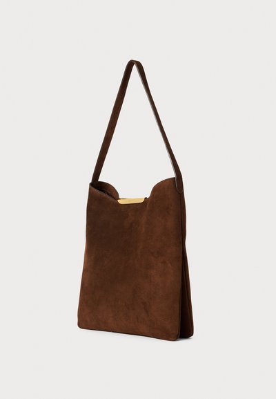 Sac à épaule en suède marron avec une forme plate, une seule sangle et un accent en métal doré en haut de l'ouverture.
