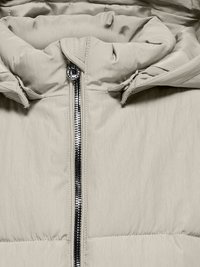 Ανοιχτό καφέ φουσκωτό μπουφάν με ψηλό γιακά, πλήρη κλείσιμο με φερμουάρ και κοσμητική υφή. Διαθέτει γυαλιστερό μαύρο φερμουάρ και μαλακό ύφασμα.