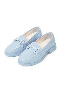 Paire de mocassins bleu clair perforés avec une chaîne décorative à l'avant, talons bas et surpiqûres sur les orteils.
