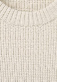 Suéter de punto crema con textura acanalada, cuello redondo y material suave de lana. El color es uniforme, sin patrones ni acentos.