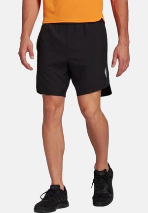 Black athletic shorts with an elastic waistband, featuring side slits and a small logo detail. Worn with black athletic shoes.