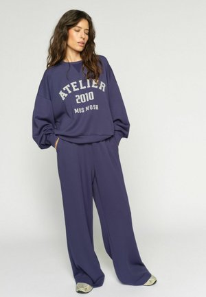 NIMA - Nohavice - crown blue