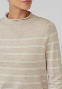 Beige trui met lichtgrijze horizontale strepen, geribbelde ronde halslijn, zachte textuur en subtiele glans in de stof.