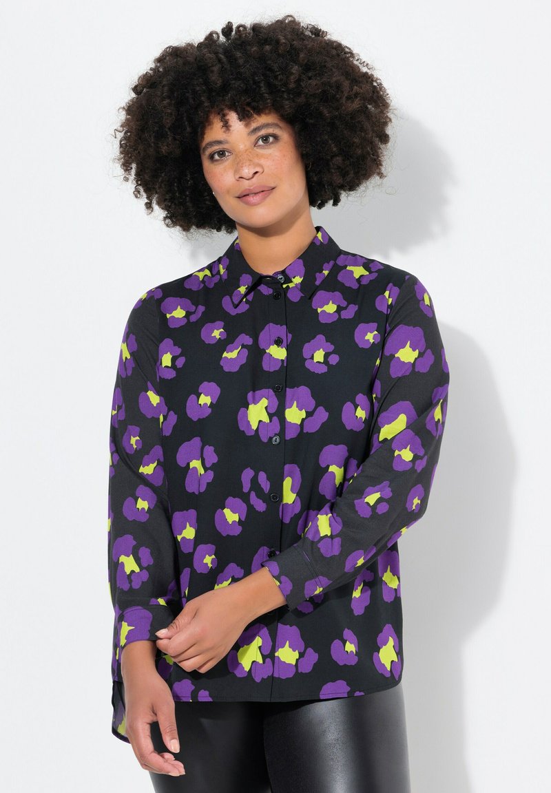 Langærmet sort skjorte med lilla og limegrøn blomsterprint, knaplukning foran og krave. Blødt, let stof med en afslappet pasform.