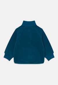 Pull-over en polaire bleu-vert avec un col haut, des poignets côtelés et une coupe décontractée. La texture est douce, avec un aspect légèrement duveteux.
