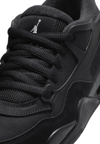 Baskets de sport noires avec un corps en mesh texturé, des accents en suède lisse, des lacets plats et une semelle en caoutchouc au profil distinct.
