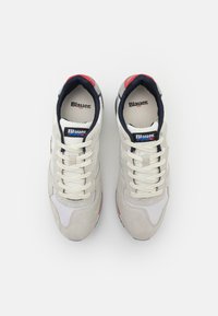Sneaker atletiche bianche e grigie realizzate in suede e mesh, con punta rotonda, lacci e dettagli in blu navy e rosso sul colletto e sulla suola.