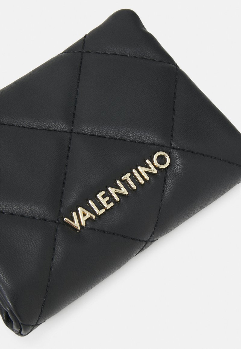 Portefeuille en cuir matelassé noir avec un logo doré "VALENTINO" sur le devant, présentant une texture lisse et un motif de couture en diagonale.