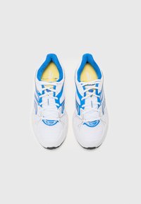 Baskets blanches avec des accents bleus, dessus en mesh pour la respirabilité, bout arrondi et semelles plates. Semelles intérieures jaunes visibles. Lacets blancs.